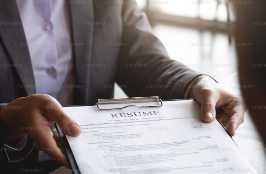 person handing someone a resume